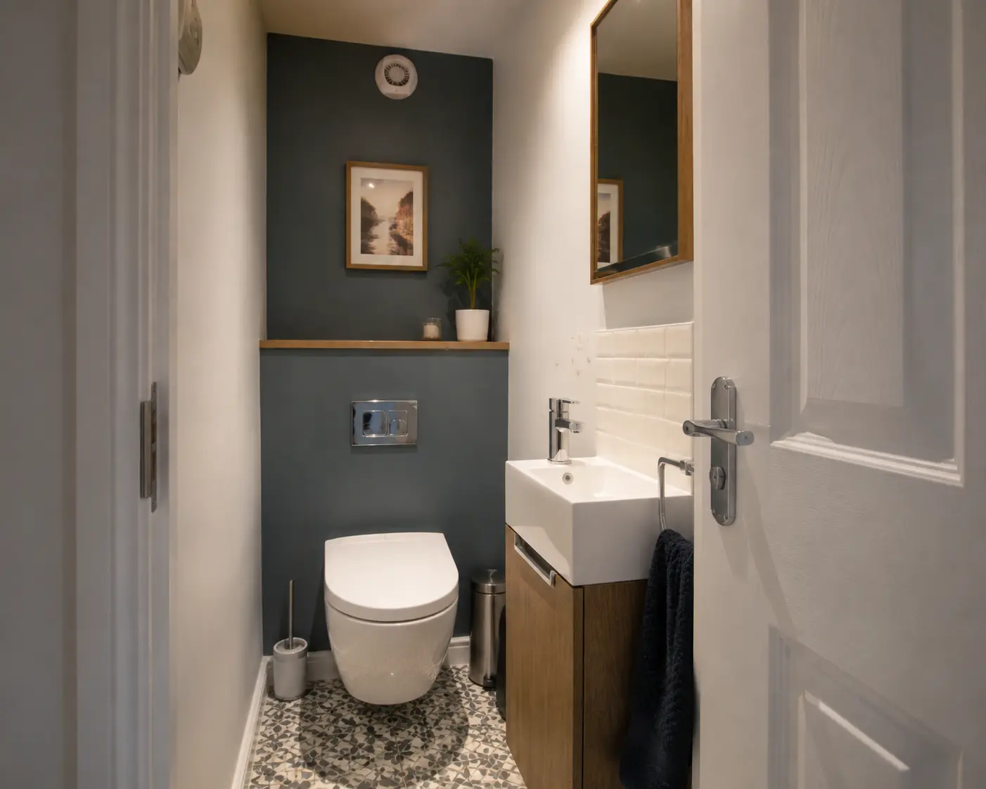 Compact downstairs toilet with a slim vanity and patterned floor