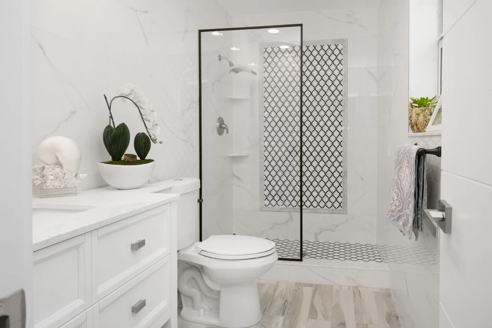 Elegant white bathroom with contemporary design featuring minimalist decor and a glass shower